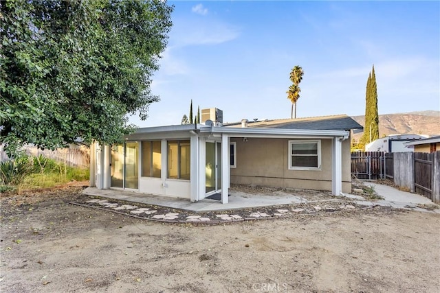 back of property with a sunroom and a patio area