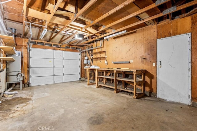 garage featuring a garage door opener, gas water heater, and a workshop area