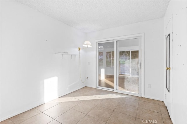 empty room featuring light tile patterned floors and a textured ceiling