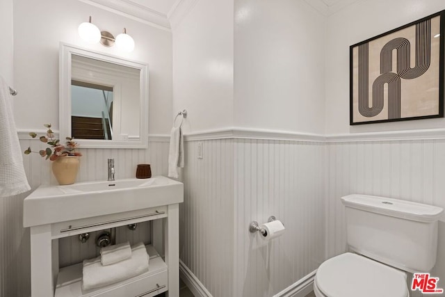 bathroom with ornamental molding, sink, and toilet