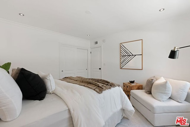 bedroom with a closet and ornamental molding