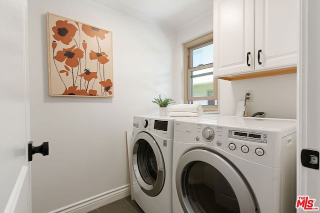 clothes washing area with dark tile patterned flooring, ornamental molding, separate washer and dryer, and cabinets