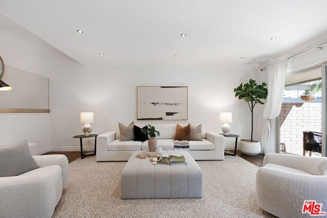 living room with ornamental molding, light hardwood / wood-style floors, and a brick fireplace