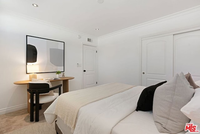 bedroom with light colored carpet, a closet, and crown molding