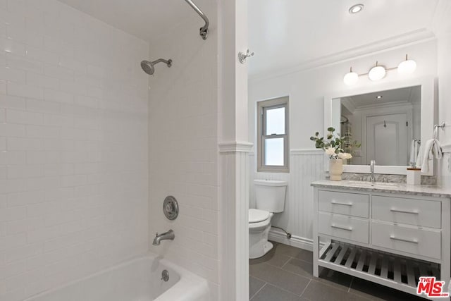 full bathroom with tiled shower / bath combo, toilet, crown molding, vanity, and tile patterned floors