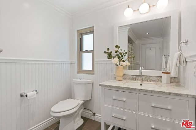 bathroom featuring tile patterned floors, crown molding, vanity, and toilet