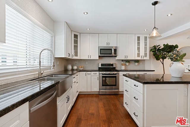 kitchen with stainless steel appliances, sink, white cabinetry, pendant lighting, and dark wood-type flooring