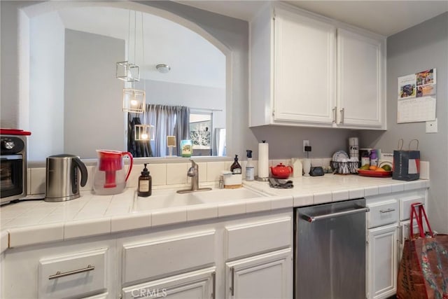 kitchen with stainless steel dishwasher, sink, white cabinets, and tile countertops