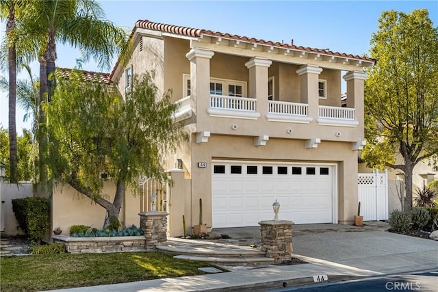 mediterranean / spanish home featuring a garage and a balcony