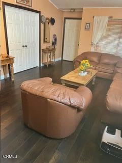 living room featuring dark hardwood / wood-style flooring and ornamental molding