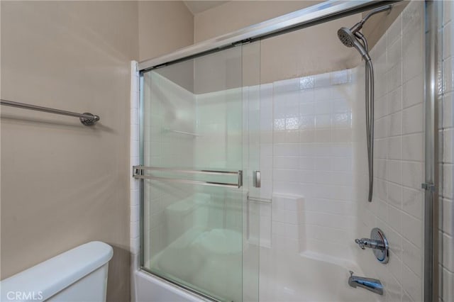 bathroom with shower / bath combination with glass door and toilet