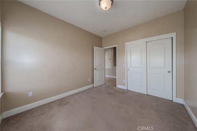 unfurnished bedroom featuring a closet and light carpet