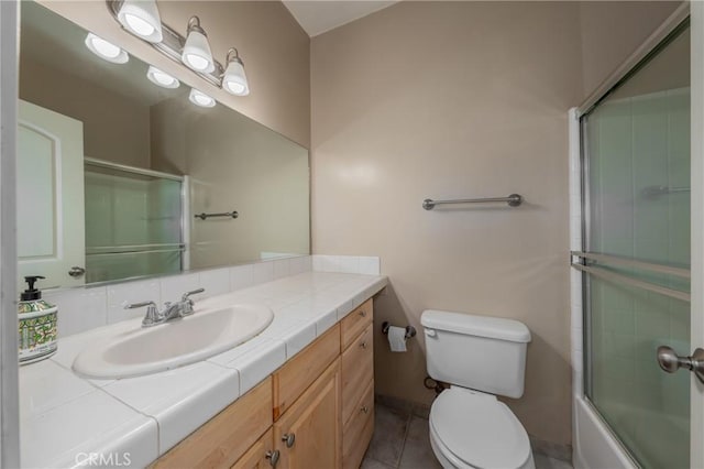 full bathroom featuring tile patterned floors, enclosed tub / shower combo, toilet, and vanity