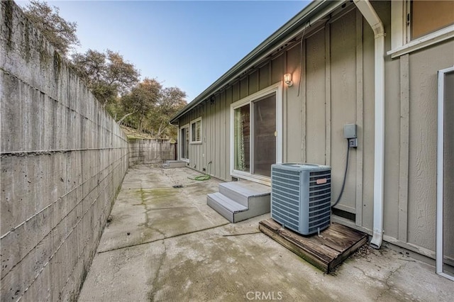 view of side of property featuring central AC unit and a patio area