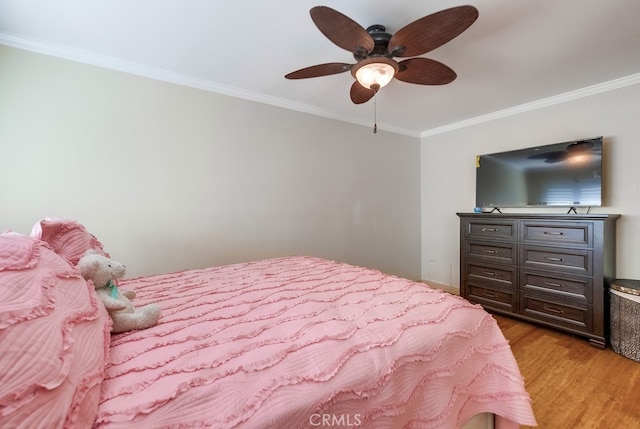 bedroom featuring ceiling fan, light hardwood / wood-style floors, and crown molding