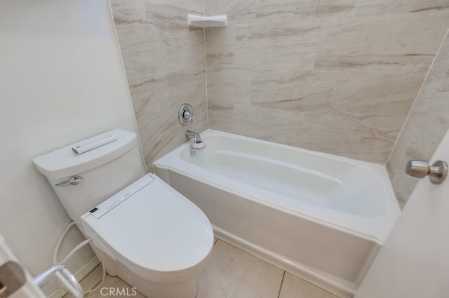 bathroom featuring tiled shower / bath, tile patterned floors, and toilet