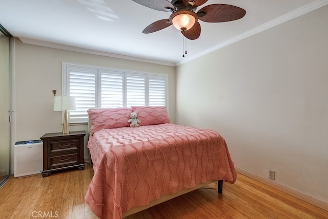 bedroom with ceiling fan, light hardwood / wood-style floors, and crown molding