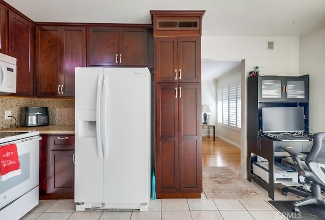 kitchen featuring white appliances, decorative backsplash, and light tile patterned floors