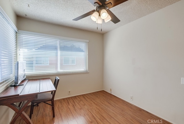 office with a textured ceiling, ceiling fan, and light hardwood / wood-style flooring