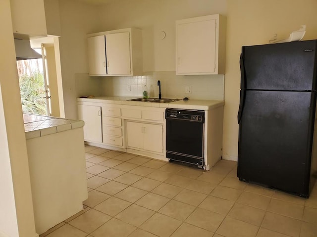 kitchen with light tile patterned floors, white cabinetry, black appliances, and sink