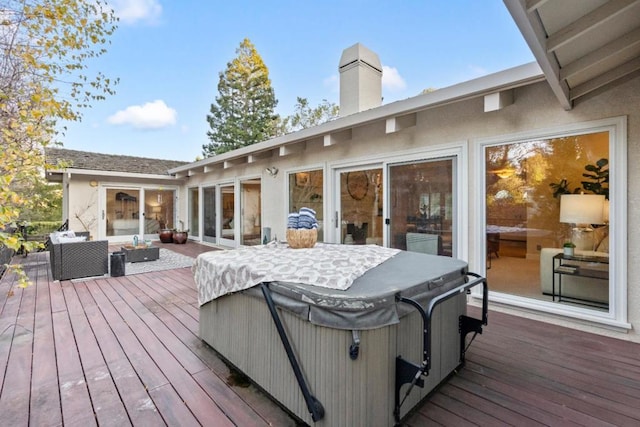 deck with a hot tub and an outdoor hangout area