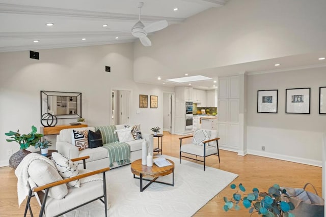 living room featuring beam ceiling, ceiling fan, and light hardwood / wood-style flooring