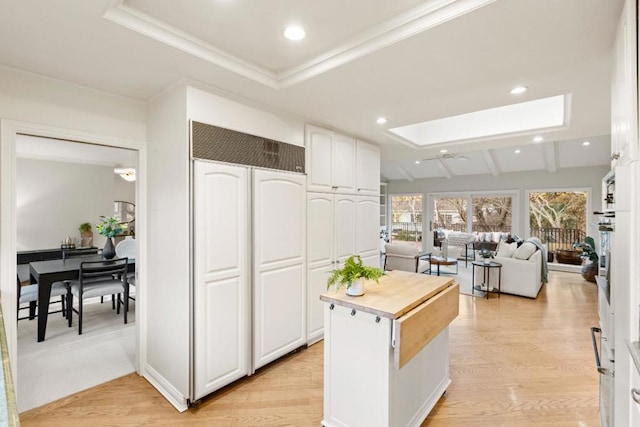 kitchen with white cabinets, light hardwood / wood-style flooring, and a kitchen island