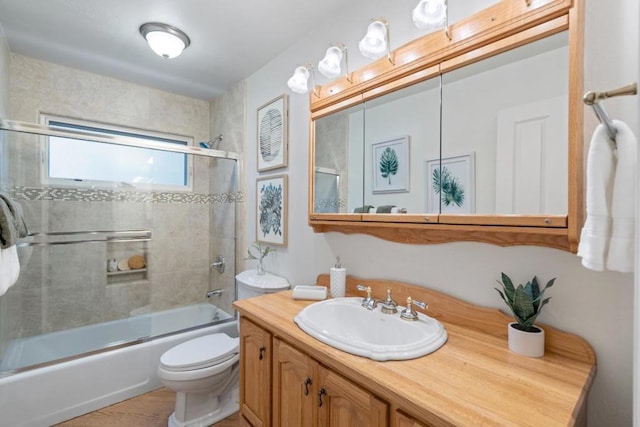 full bathroom with toilet, vanity, and shower / bath combination with glass door