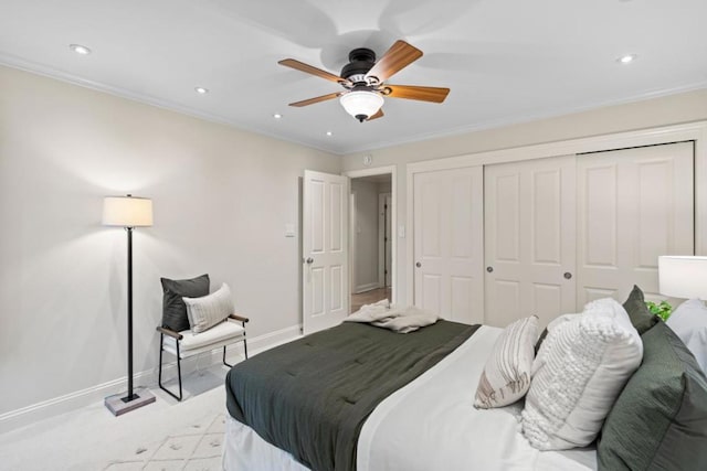 bedroom with ceiling fan, light carpet, a closet, and ornamental molding