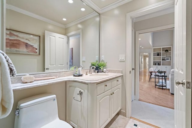 bathroom featuring toilet, vanity, crown molding, and built in shelves