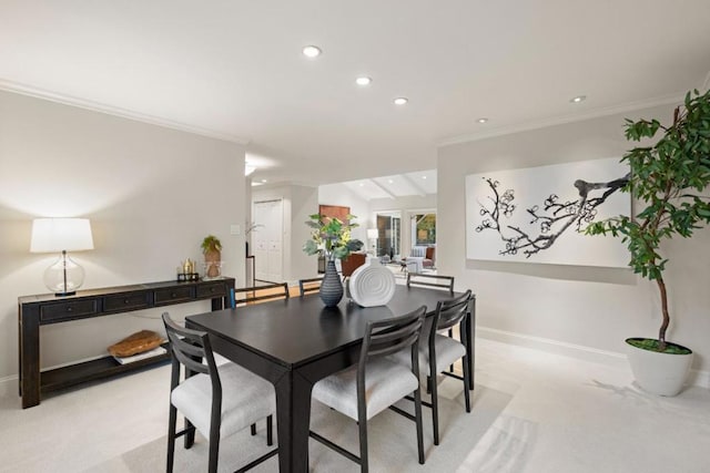 carpeted dining space featuring lofted ceiling and crown molding