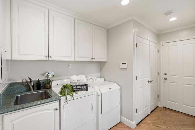 laundry area featuring light hardwood / wood-style floors, washer and clothes dryer, cabinets, ornamental molding, and sink