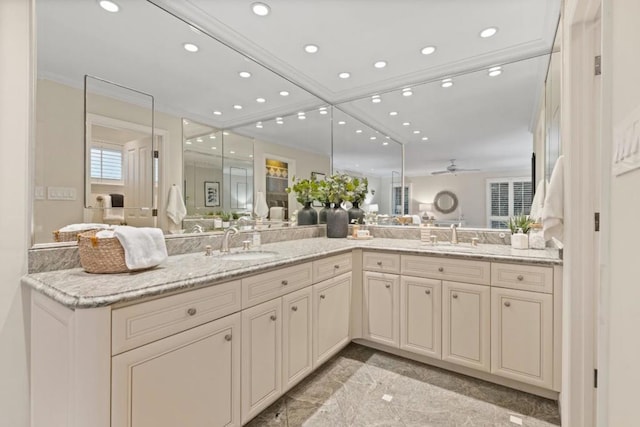 bathroom featuring ceiling fan, ornamental molding, and vanity