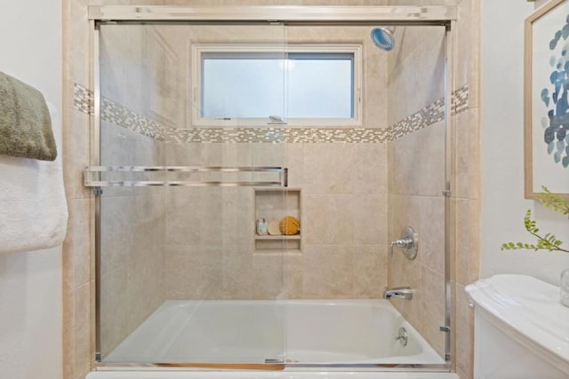 bathroom featuring shower / bath combination with glass door and toilet