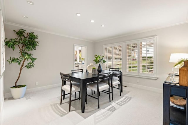 dining room with light colored carpet and ornamental molding