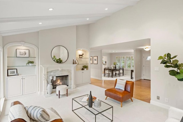 living room with light hardwood / wood-style flooring, beam ceiling, and a fireplace