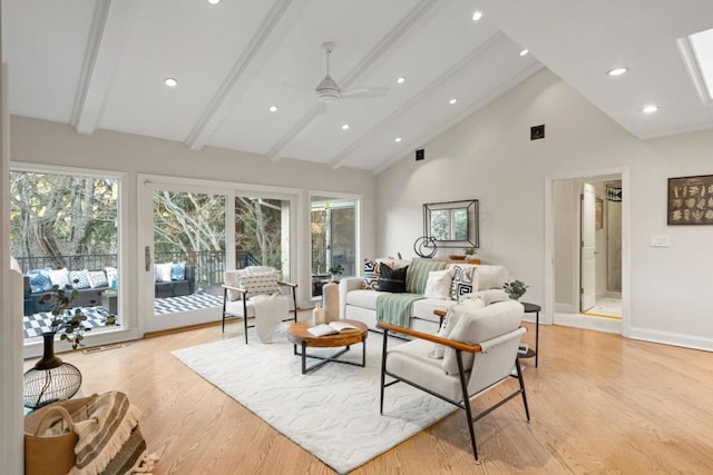 living room featuring light wood-type flooring, ceiling fan, beam ceiling, and high vaulted ceiling