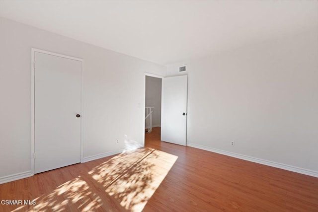 unfurnished bedroom featuring wood-type flooring and a closet