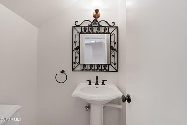 bathroom with lofted ceiling and toilet