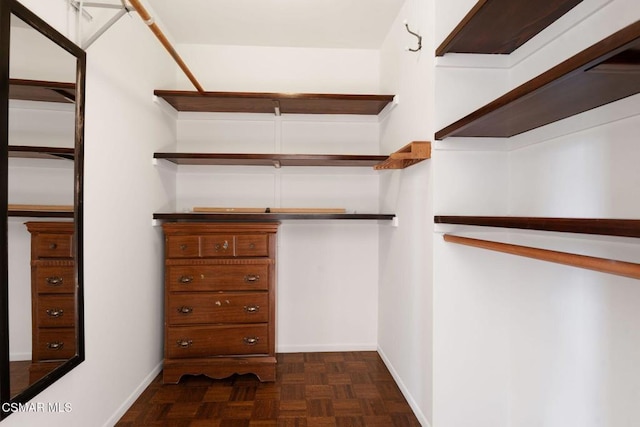 walk in closet featuring dark parquet flooring