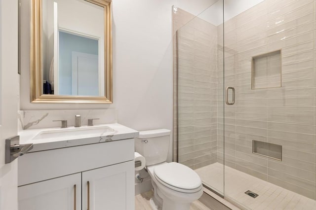 bathroom with toilet, a shower with door, and vanity