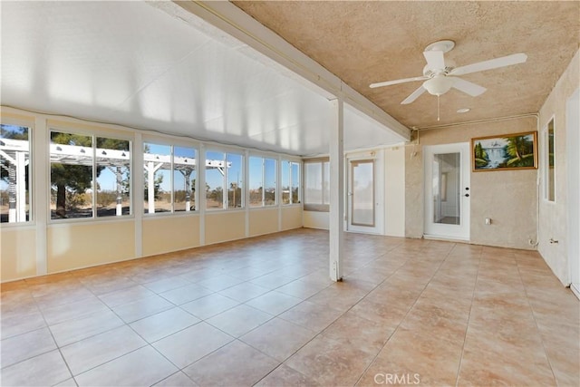 unfurnished sunroom featuring ceiling fan