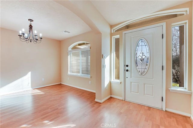 entrance foyer with light wood-type flooring and a chandelier