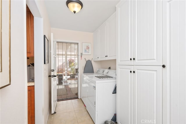 laundry room featuring cabinets, light tile patterned floors, and independent washer and dryer