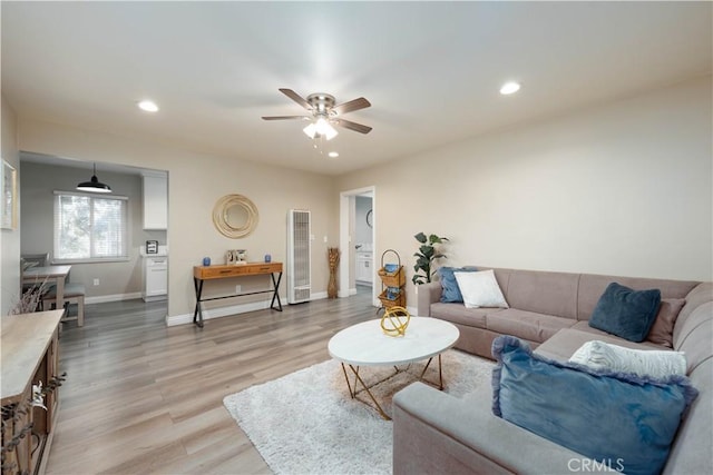 living room with light wood-type flooring and ceiling fan