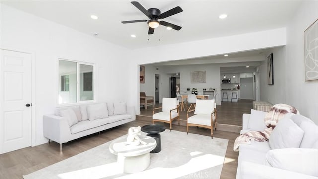 living room featuring ceiling fan and dark hardwood / wood-style flooring