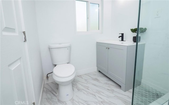 bathroom featuring toilet, vanity, and a shower