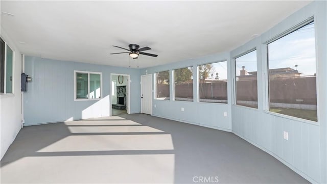 unfurnished sunroom with ceiling fan