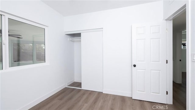 unfurnished bedroom with a closet and hardwood / wood-style flooring