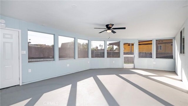 unfurnished sunroom with ceiling fan